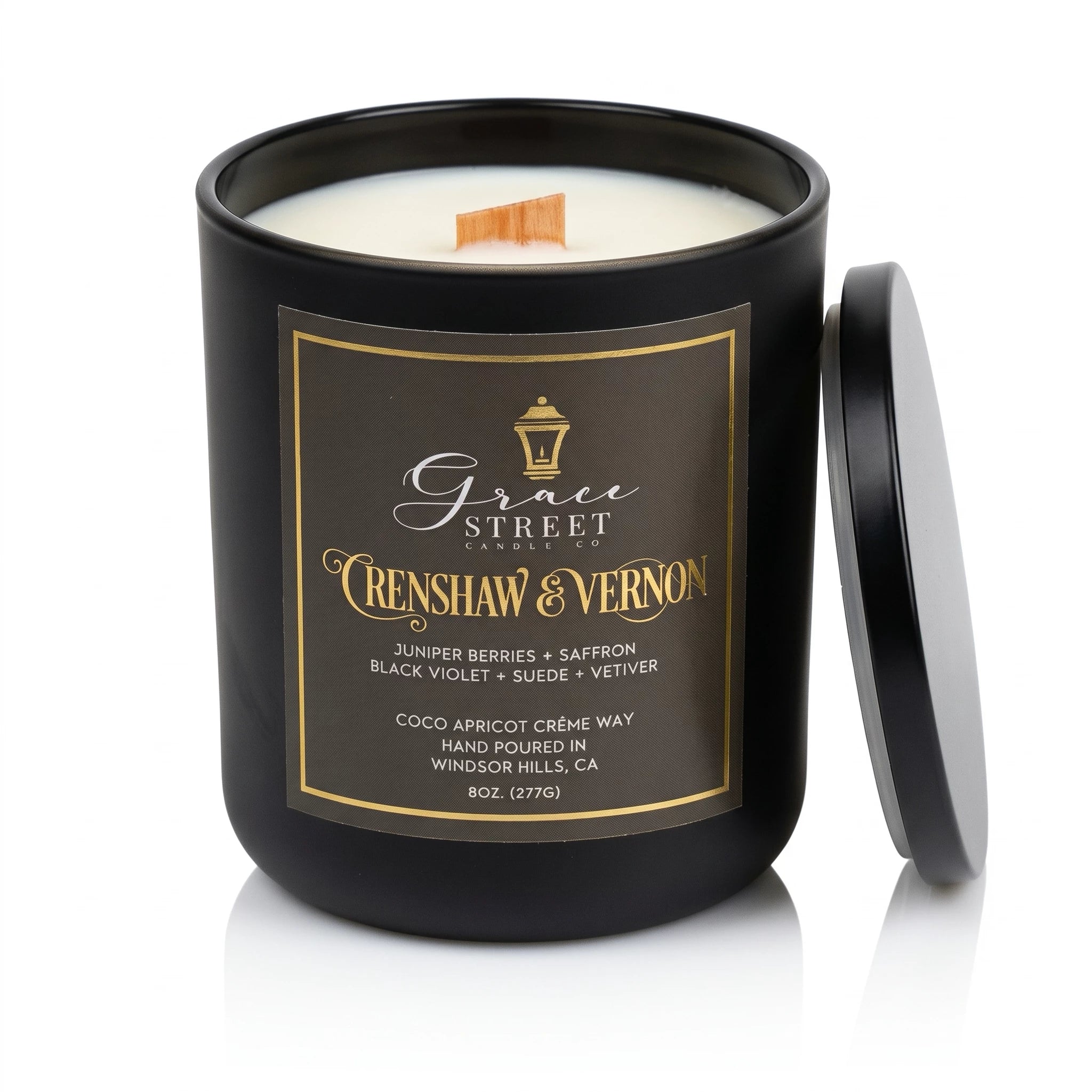 A black glass jar candle with a matching black lid leaning against it on a white background. The front label reads Grace Street Candle and Crenshaw & Vernon, with white wax visible at the top and a small wooden wick.